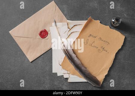 Lettera vintage e busta con penna piuma sul tavolo Foto Stock