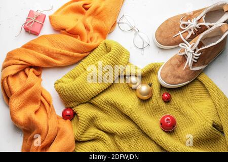 Composizione natalizia con abiti eleganti e accessori su sfondo bianco Foto Stock