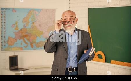 Insegnante di vecchia generazione scolastica. Insegnante di uomo intelligente senior presso la lavagna. Docente esperto. Insegnante maturo godere di insegnamento. Condivisione delle conoscenze. Ottenere le certificazioni per programmi specifici. Foto Stock