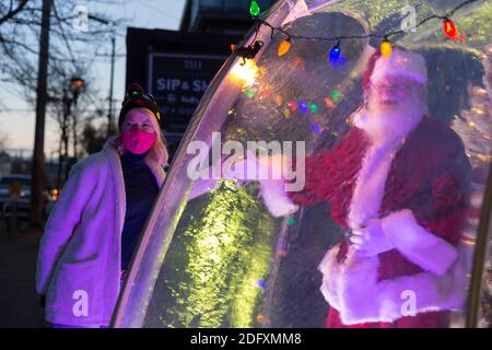 Seattle, Washington, Stati Uniti. 6 dicembre 2020. DaN Kemmis, noto come Seattle Santa, si pone per una foto con Kris Bennett dall'interno di una bolla di plastica protettiva nel quartiere Greenwood di Seattle. Incapace di programmare eventi privati a causa della pandemia del coronavirus, Kemmis sta facendo apparizioni pubbliche fisicamente distanziate con alcune donazioni che avvantaggiano i rifugi locali dei senzatetto. Credit: Paul Christian Gordon/Alamy Live News Foto Stock