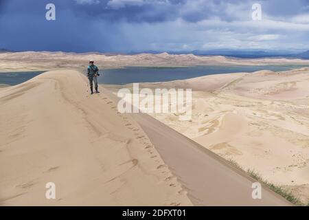 Escursione turistica lungo il bordo della duna di sabbia. Grande barkhan in Mongolia deserto di dune sabbiose Mongol Els. Govi-Altay, Mongolia. Foto Stock