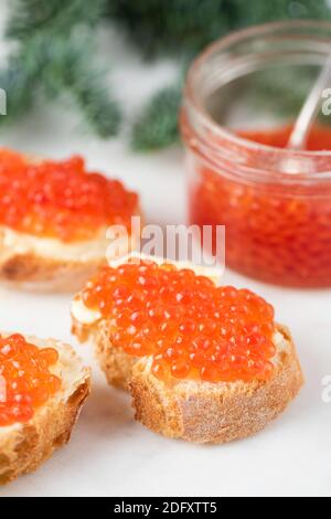 Toast alla canape con caviale rosso su sfondo bianco. Vista in primo piano. Antipasto di lusso Foto Stock