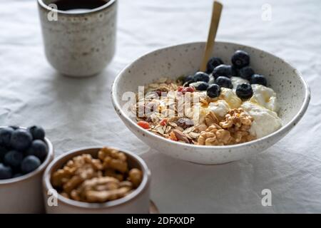 Colazione salutare con muesli di granola e yogurt in ciotola su sfondo bianco della tavola Foto Stock