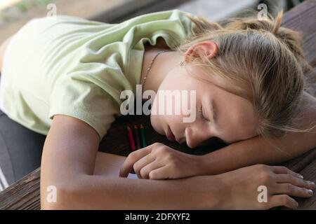 Ragazza adolescente che si annuita su una scrivania in una stanza di studio  Foto stock - Alamy