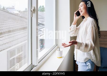 Donna ridente che chiama al telefono Foto Stock