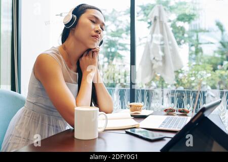 Donna d'affari che ascolta musica rilassante Foto Stock