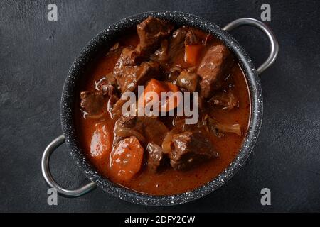 Manzo Bourguignon in una padella. Stufato con vino rosso, carote, cipolle, aglio, un bouquet garni, e guarnito con cipolle di perle, funghi e pancetta. Francese Foto Stock