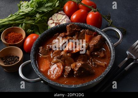 Manzo Bourguignon in una padella. Stufato con vino rosso, carote, cipolle, aglio, un bouquet garni, e guarnito con cipolle di perle, funghi e pancetta. Francese Foto Stock