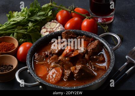 Manzo Bourguignon in una padella. Stufato con vino rosso, carote, cipolle, aglio, un bouquet garni, e guarnito con cipolle di perle, funghi e pancetta. Francese Foto Stock