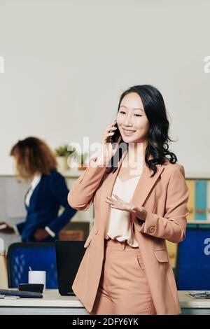 Donna d'affari che discute il progetto al telefono Foto Stock