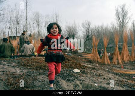 Ganderbal, India. 07 dicembre 2020. Una ragazza corre attraverso un ghat vicino al fiume sindh.A valle tra la Grande catena montuosa dell'Himalaya e la catena montuosa del PIR Panjal, Kashmir è un luogo di bella semplicità e incontaminata bellezza naturale. Il Kashmir ha una varietà di terreni che vanno da laghi, montagne innevate, colline conifere baciate ai fiumi alimentati da ghiacciai. Credit: SOPA Images Limited/Alamy Live News Foto Stock