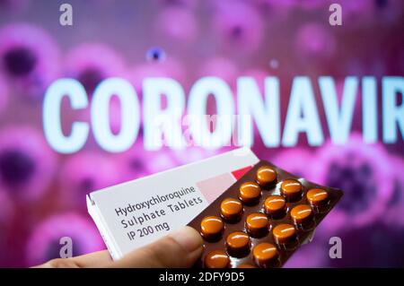 Compresse di idrossiclorochina solfato con coronavirus scritto sullo sfondo Foto Stock