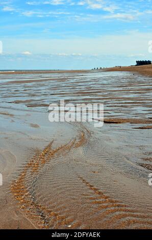 Acqua che forma increspature sulla spiaggia come la marea si ritirano a Chapel st Leonards, con il North Sea Observatory in background, Lincolnshire UK Foto Stock