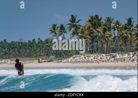 VARKALA, INDIA - Mar 14, 2020: Un indiano Maschile Surf in stile con le mani alle spalle Foto Stock