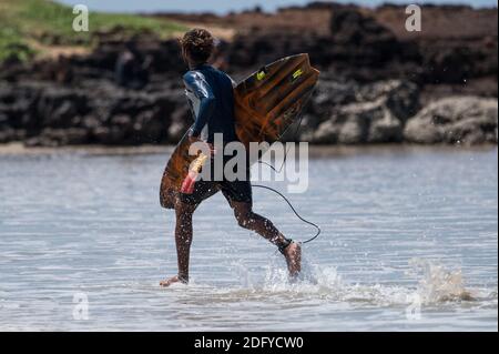 VARKALA, INDIA - Mar 14, 2020: Un surfer indiano maschio che corre verso la cenere Foto Stock