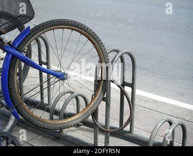 Un blocco di parcheggio per biciclette di una ruota sul sentiero accanto a una strada. Foto Stock