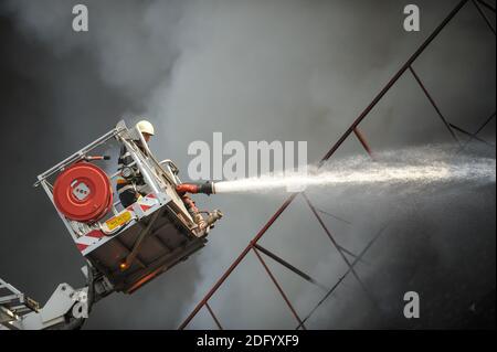 Bucarest, Romania - 7 luglio 2012: I vigili del fuoco cercano di spegnere le fiamme che hanno ingollato un edificio. Foto Stock