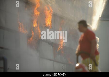 Bucarest, Romania - 7 luglio 2012: I vigili del fuoco cercano di spegnere le fiamme che hanno ingollato un edificio. Foto Stock