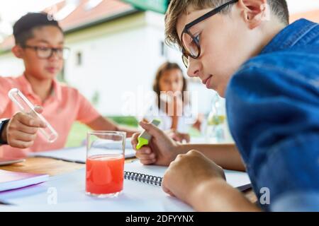 I bambini imparano nel corso di vacanza di insegnamento di chimica nel campo di tutoring durante le vacanze estive Foto Stock