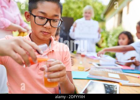 I bambini sperimentano con reagenti nella classe di insegnamento chimico di la scuola estiva Foto Stock