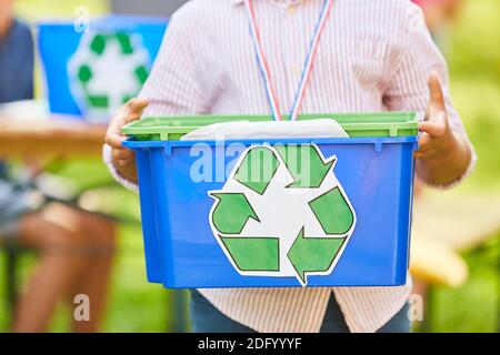 Il bambino tiene una scatola con il simbolo di riciclaggio in un progetto per tutela ambientale ed ecologia Foto Stock