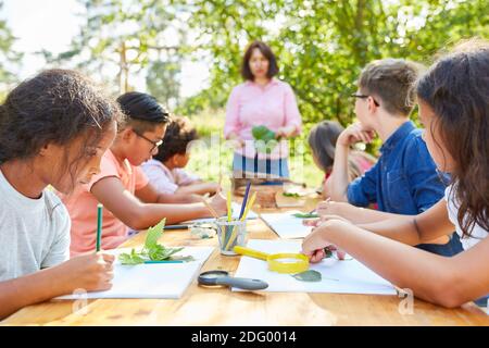 I bambini fanno artigianato e disegnano piante in classe artistica creativa al campo estivo Foto Stock