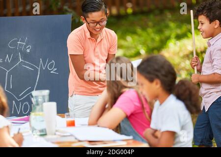 I bambini si divertono imparando chimica lezioni di tutoring in estate corso Foto Stock