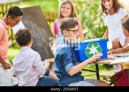 I bambini imparano a conoscere la sostenibilità e la tutela ambientale nel riciclaggio progetto nel campo di vacanza Foto Stock