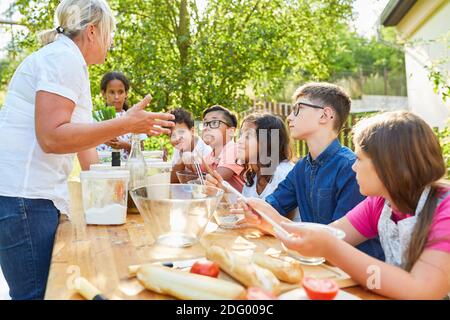 I bambini imparano a cucinare insieme in modo sano nel campo estivo lezione di cucina Foto Stock