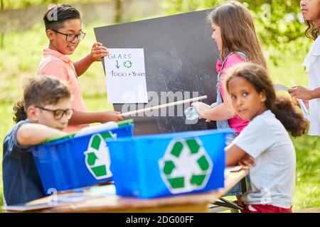 Il gruppo di bambini apprende la sostenibilità e la protezione ambientale in uno spreco campagna di riciclaggio del vetro Foto Stock