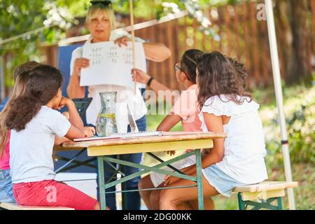 Insegnante dà lezioni di insegnamento in matematica nella scuola estiva corso di vacanza Foto Stock