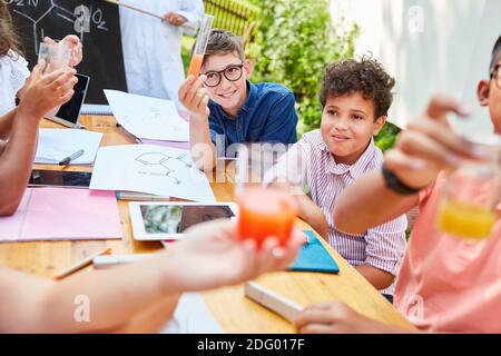 I bambini di gruppo fanno esperimenti in chimica che insegnano le lezioni di estate scuola Foto Stock