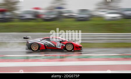 Una panoramica di una vettura da corsa mentre si guida su una pista. Foto Stock