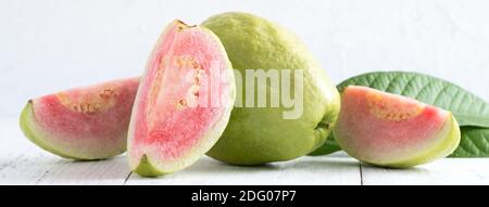 Primo piano di deliziosa bella guava rossa con foglie fresche di verde isolato su sfondo bianco tavolo, studio di ripresa con spazio copia. Foto Stock