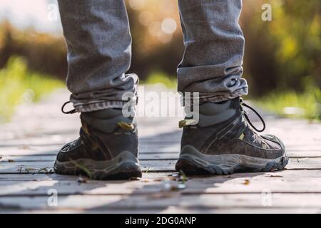 Primo piano di scarponi da montagna con ramponi e ghette da neve con raggi  solari retroilluminati e spruces nevosi sullo sfondo Foto stock - Alamy