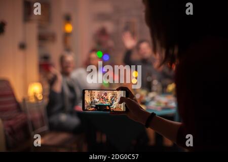 Nipote che scatta foto della sua famiglia alla celebrazione di natale. Foto Stock