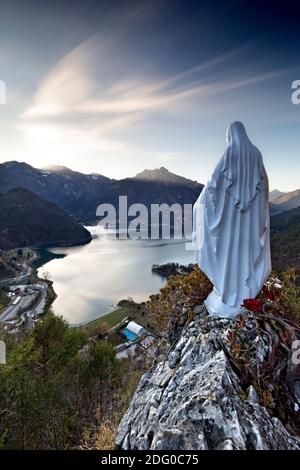 La Madonnina di Besta e il Lago di Ledro. Sullo sfondo, i monti Tremalzo, Sarbano e Corno. Ledro, provincia di Trento, Trentino Alto Adige, Italia. Foto Stock