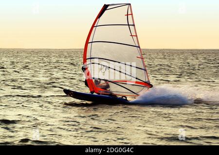 Silhouette di un windsurf su un golfo, che si muove a grande velocità Foto Stock