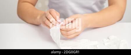 Primo piano delle mani del medico mette su guanti bianchi in lattice sul tavolo bianco pulito Foto Stock