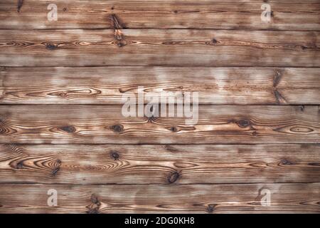 Un bel fondo universale da tavole di legno testurizzate di conifere. Tavole invecchiate sparando e spazzolando. Foto Stock