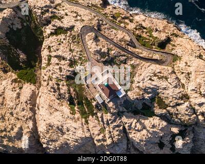 Vista ad occhio di uccello del sole di prima mattina sul faro a. La pietra in Ile Rousse nella regione Balagne di Corsica Foto Stock