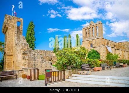Rovine di Bellapais Abbazia monastero edificio in pietra nel quartiere di Kyrenia Girne, cielo blu bianco sfondo nuvole, Cipro del Nord Foto Stock