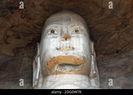 Grotte di Yungang vicino a Datong nella provincia di Shanxi, Cina. Grande statua antica di Buddha in una grotta di Yungang che mostra i dettagli della testa. Foto Stock