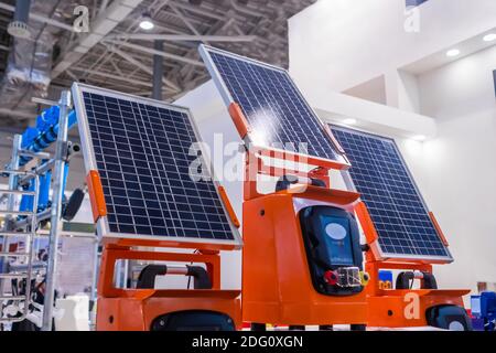 Pannelli solari fotovoltaici automatici che lavorano alla fiera della tecnologia moderna Foto Stock