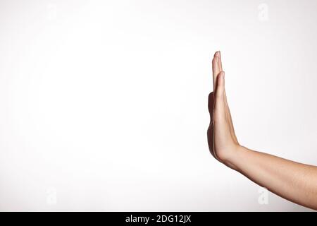 Elegante mano femminile che mostra Stop Gesture su sfondo bianco. Palm premere su qualcosa. Copia spazio. Foto Stock
