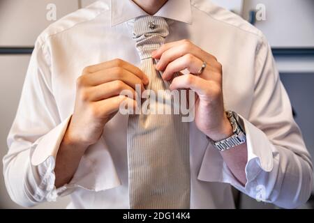 ragazzo che stabilisce il suo legame prima di celebrare il matrimonio Foto Stock