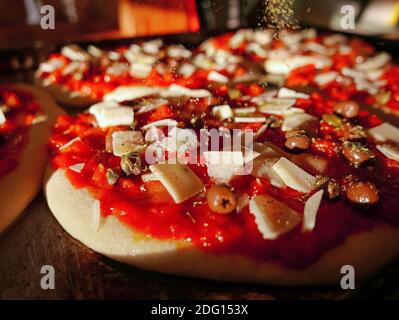 Pizza tradizionale italiana con mozzarella di pomodoro e olive, preparazione del prodotto Foto Stock
