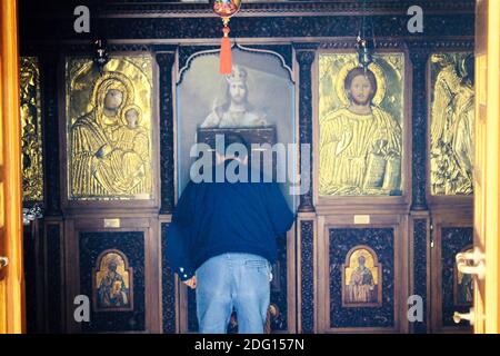 Pellegrini che pregano all'interno di una chiesa ortodossa greca ad Atene, Grecia - Marzo 12 2020. Foto Stock