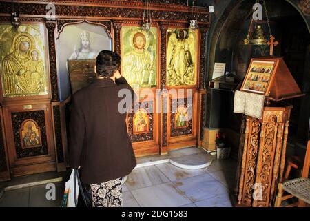 Pellegrini che pregano all'interno di una chiesa ortodossa greca ad Atene, Grecia - Marzo 12 2020. Foto Stock