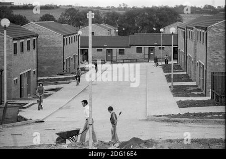 Milton Keynes New Town Inghilterra anni '1970 nuova città in fase di sviluppo, case costruite, ma non tutti i lavori sono stati ancora completati, giardini non piantati, ma nuovi residenti si stanno trasferendo. Bambini che giocano nella strada vuota con le loro biciclette 1977 Milton Keynes, Buckinghamshire HOMER SYKES Foto Stock